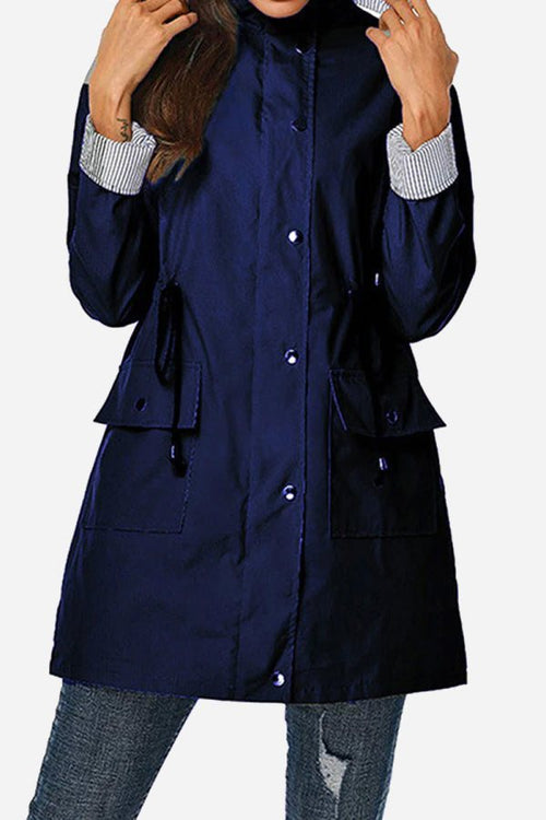 Women's navy hooded water resistant windbreaker jacket with striped cuffs and multiple pockets