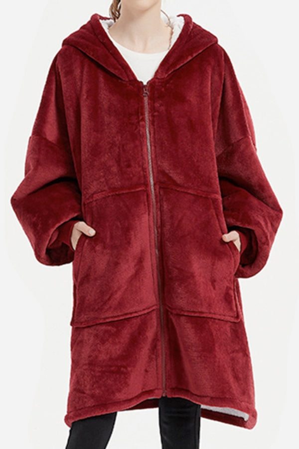 Oversized ultra soft hooded blanket in red with front zipper and large pockets, made of plush flannel and sherpa material for extra warmth.