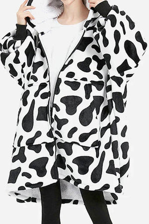 Oversized ultra soft hooded blanket with black and white cow print, front zipper, large pocket, and cozy hood