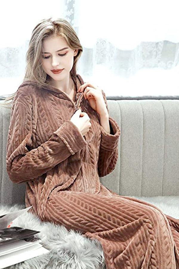 Woman wearing stylish brown flannel hooded nightgown with zipper sitting on couch