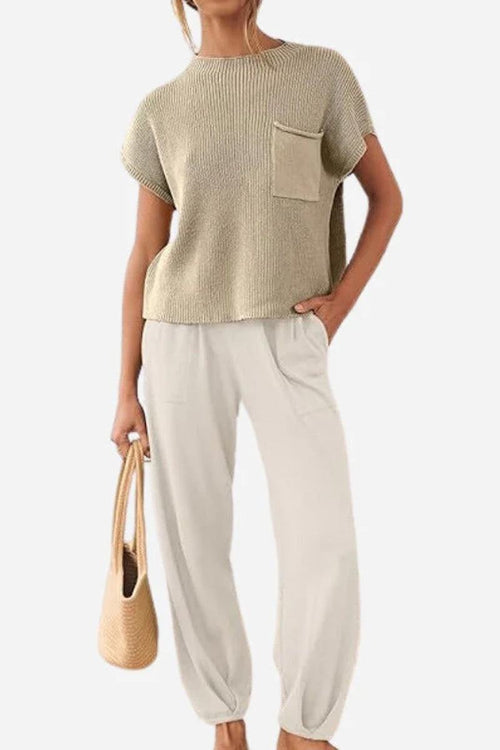 Woman wearing Comfy Couture Knit Sweater two-piece set with knit pullover and high-waisted pants, holding a bag