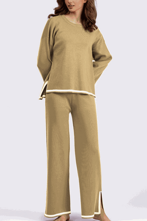 Woman wearing a beige long sleeved relaxed fit lounge two-piece set with wide-leg pants and side slits