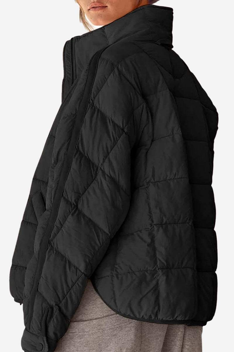 woman wearing lightweight puffer travel jacket standing outdoors against clear sky