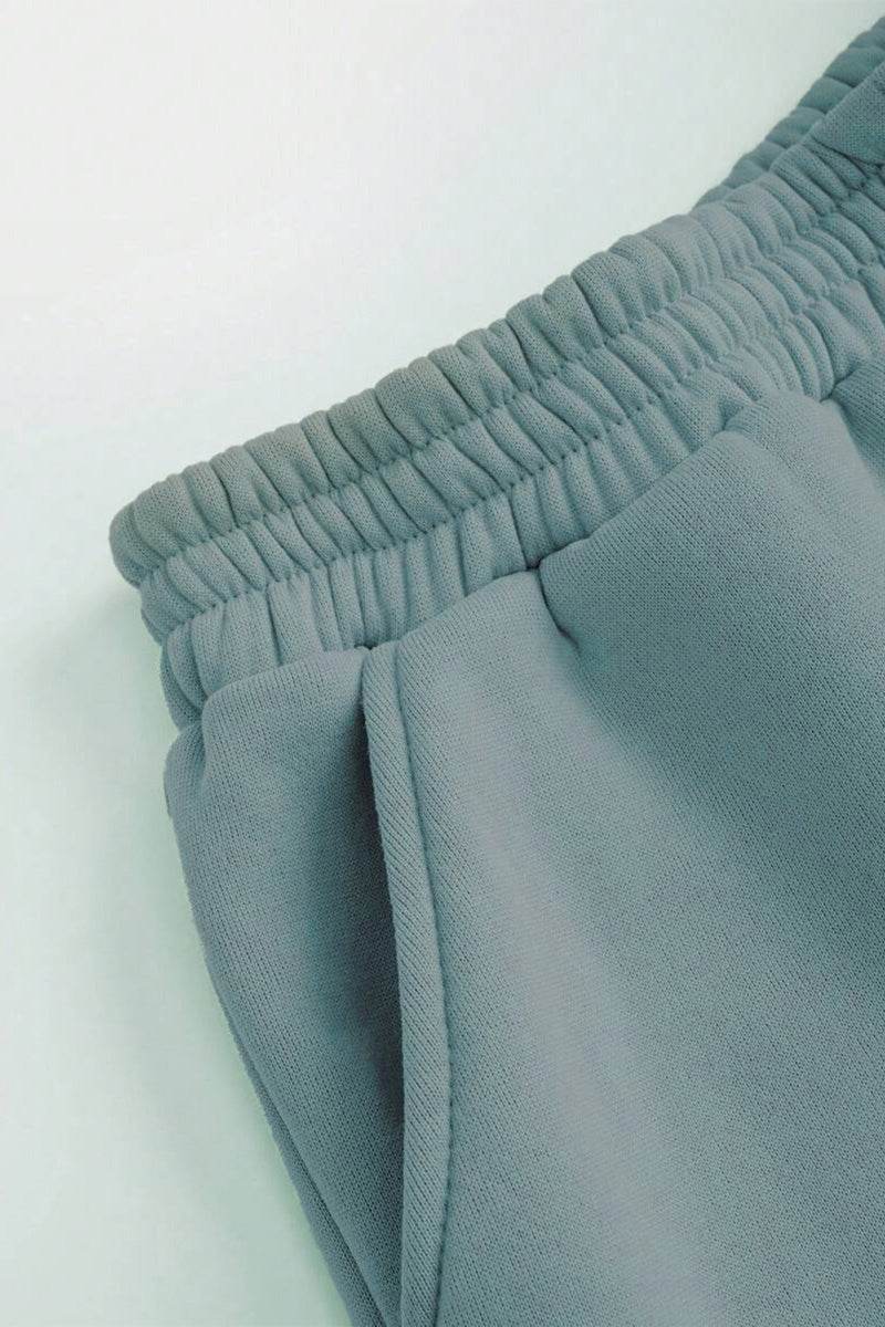 Close-up of grey cotton-blended two-piece tracksuit with elastic waistband and pocket detailing