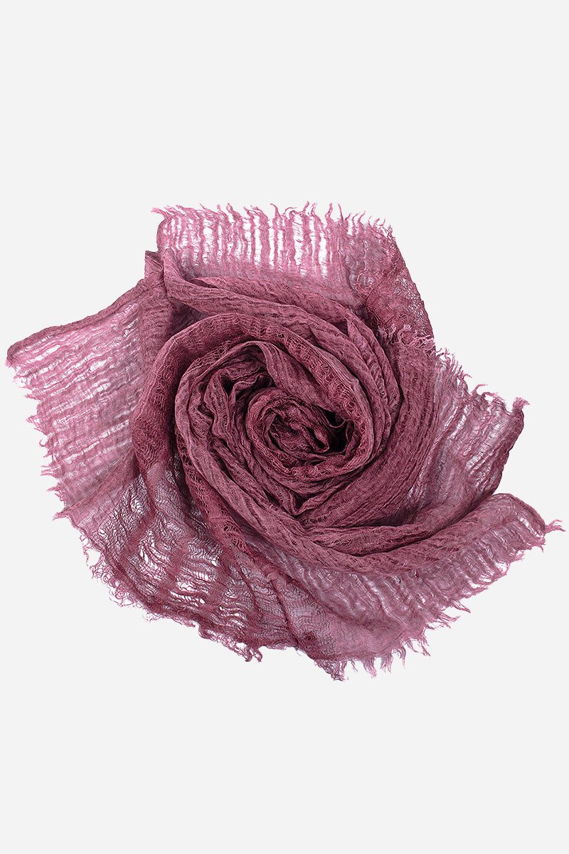 Soft lightweight linen scarf in mauve with frayed edges, folded in a rose shape