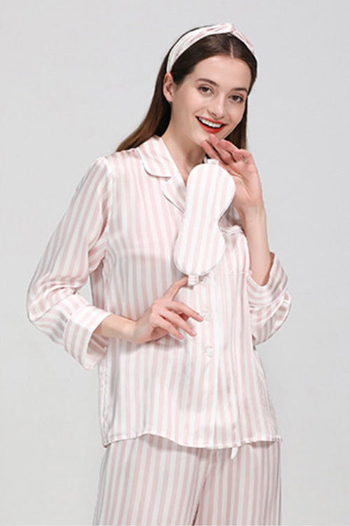 Woman wearing 100% mulberry silk striped long sleeve pajama set holding matching silk eye mask