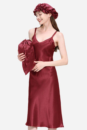 woman wearing mulberry silk elegant night dress holding matching silk pillow and wearing silk sleep cap