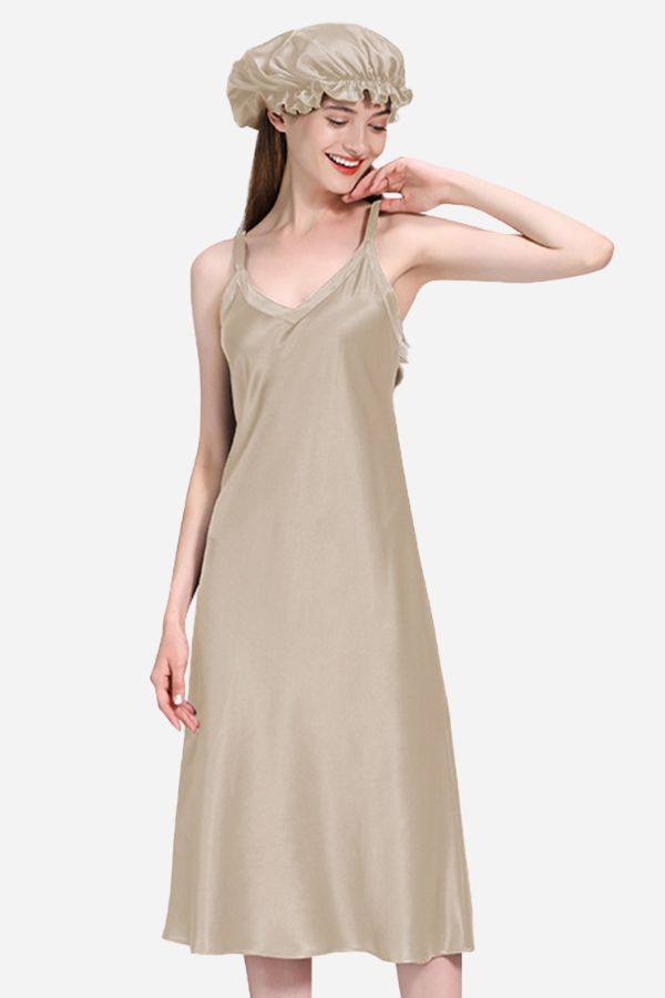 Woman wearing beige 100% mulberry silk elegant night dress with matching silk bonnet against white background