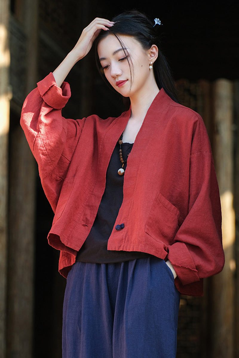Woman wearing a loose, open-front ramie linen and cotton cardigan in deep red with long sleeves and pockets