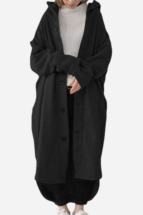 Oversized black buttoned hooded coat on person wearing casual outfit