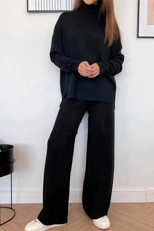 Woman wearing black knitted turtleneck two-piece set with wide-leg pants and white sneakers indoors