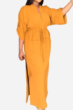 All-Day Drape Dress in mustard yellow with adjustable waist tie and front slit, breathable polyester fabric, ankle-length style.