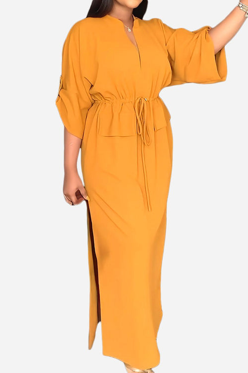 All-Day Drape Dress in mustard yellow with adjustable waist tie and front slit, breathable polyester fabric, ankle-length style.