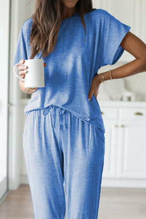 Woman wearing blue ultra-soft two-piece loungewear set holding a white mug indoors