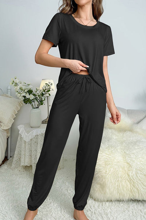 Woman wearing black My Go To Loungewear soft breathable two-piece set in cozy home setting