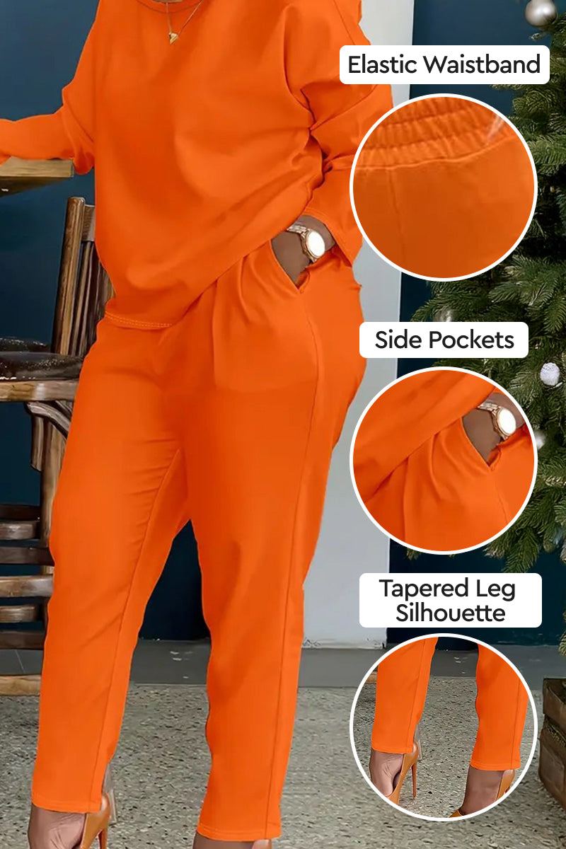Vibrant orange cotton two-piece set with elastic waistband, side pockets, and tapered leg silhouette.