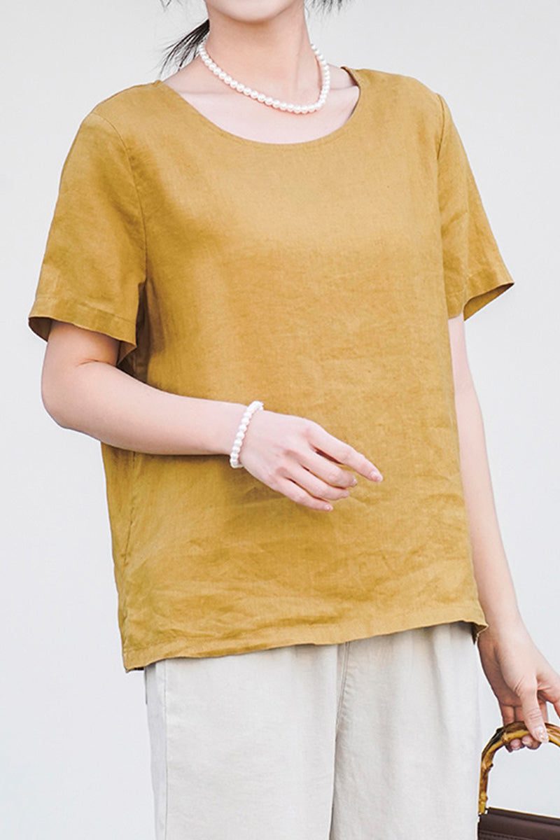 Woman wearing mustard 100% pure linen breathable classic shirt with short sleeves and round neckline.