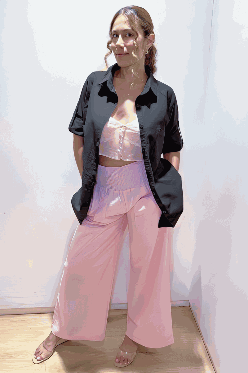 Woman wearing oversized linen-leaved-in set with black linen-blend shirt and pink palazzo pants, standing against white background