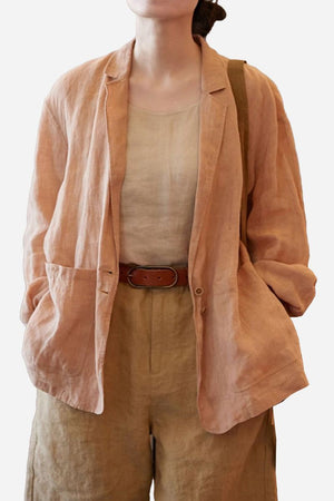 Peach 100% linen jacket shirt with notched lapel collar and functional pockets, worn layered over beige linen top and pants, breathable lightweight fabric.