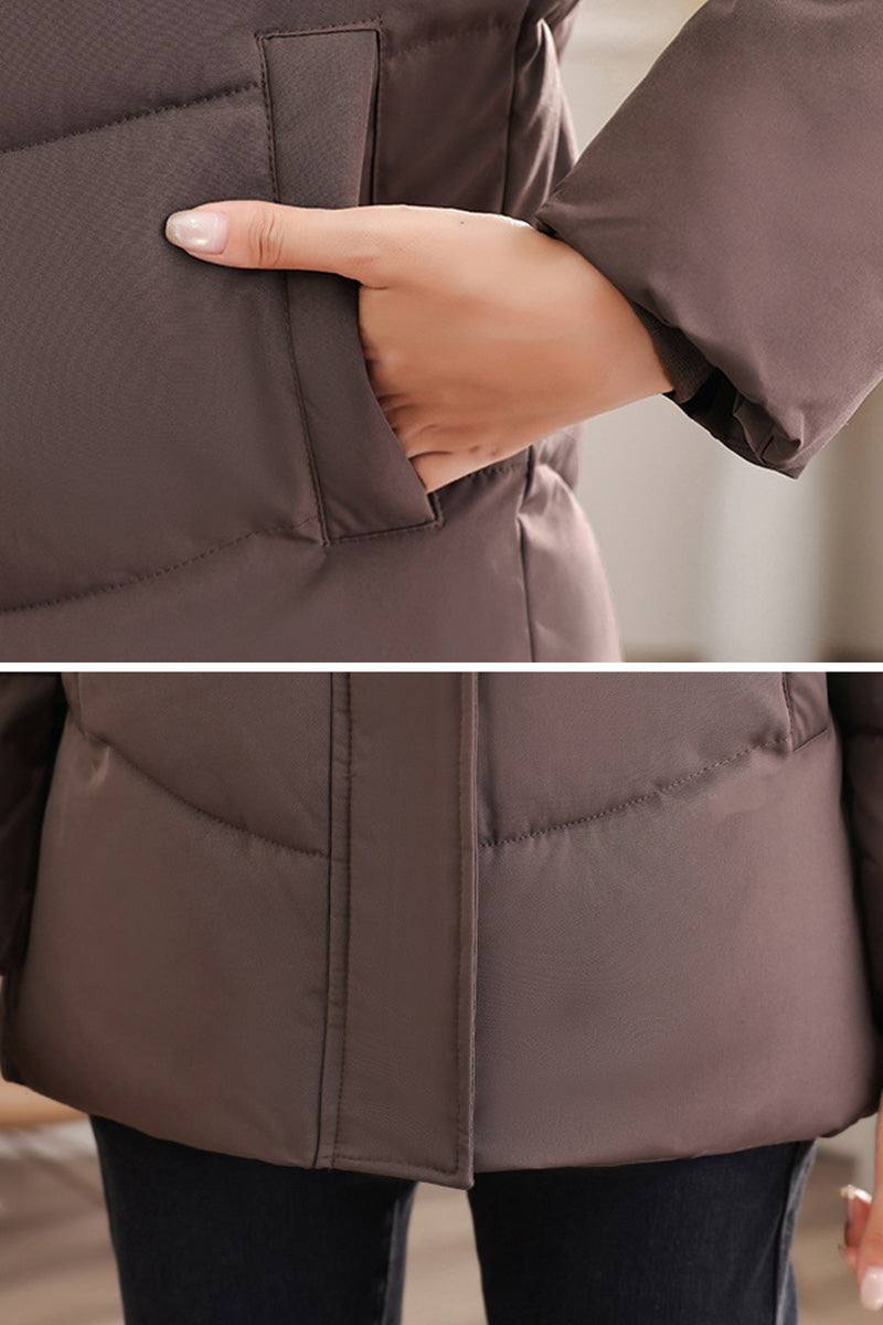 Close-up of hand in pocket of brown Everyday Warmth mid-length hooded coat with insulated 5-layer thermal construction.