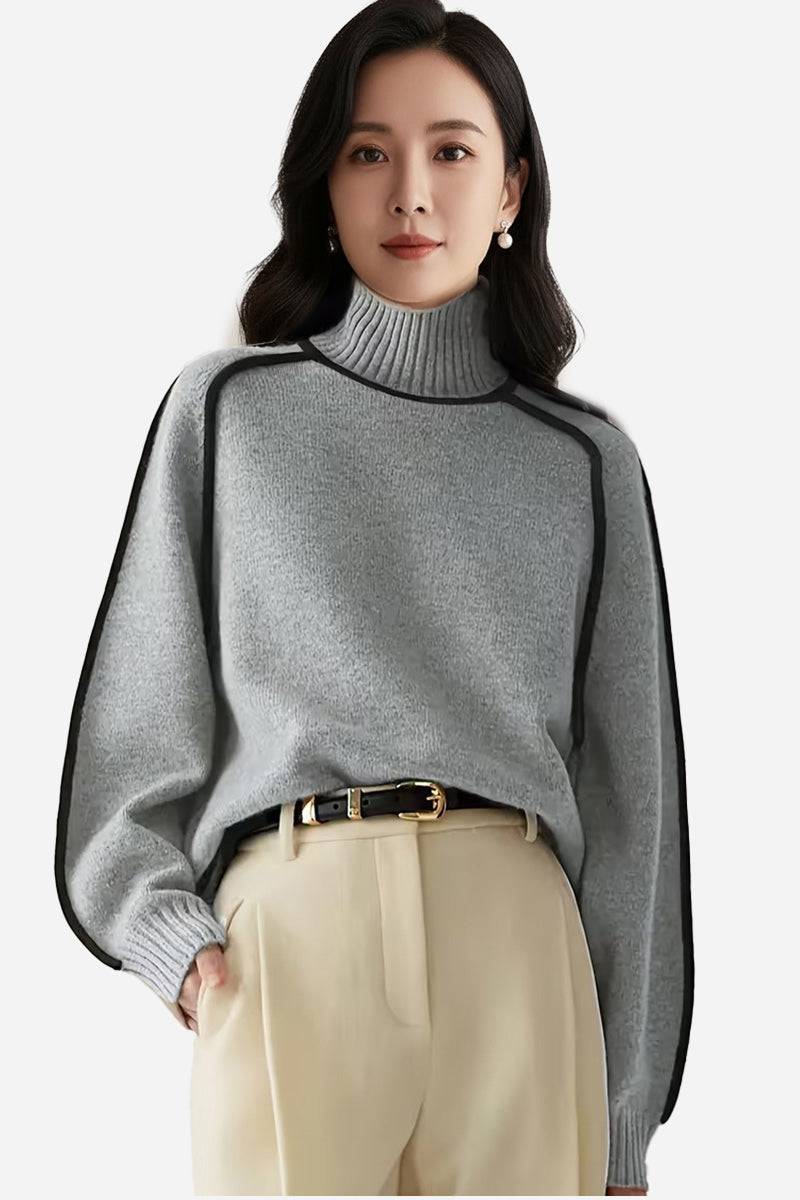 Woman wearing a soft gray Zero Itch Turtleneck Sweater with black slimming contrast trim and beige trousers