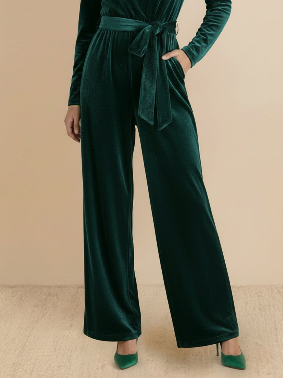 Woman wearing deep V-neck velvet suit with long sleeves and wide-leg pants