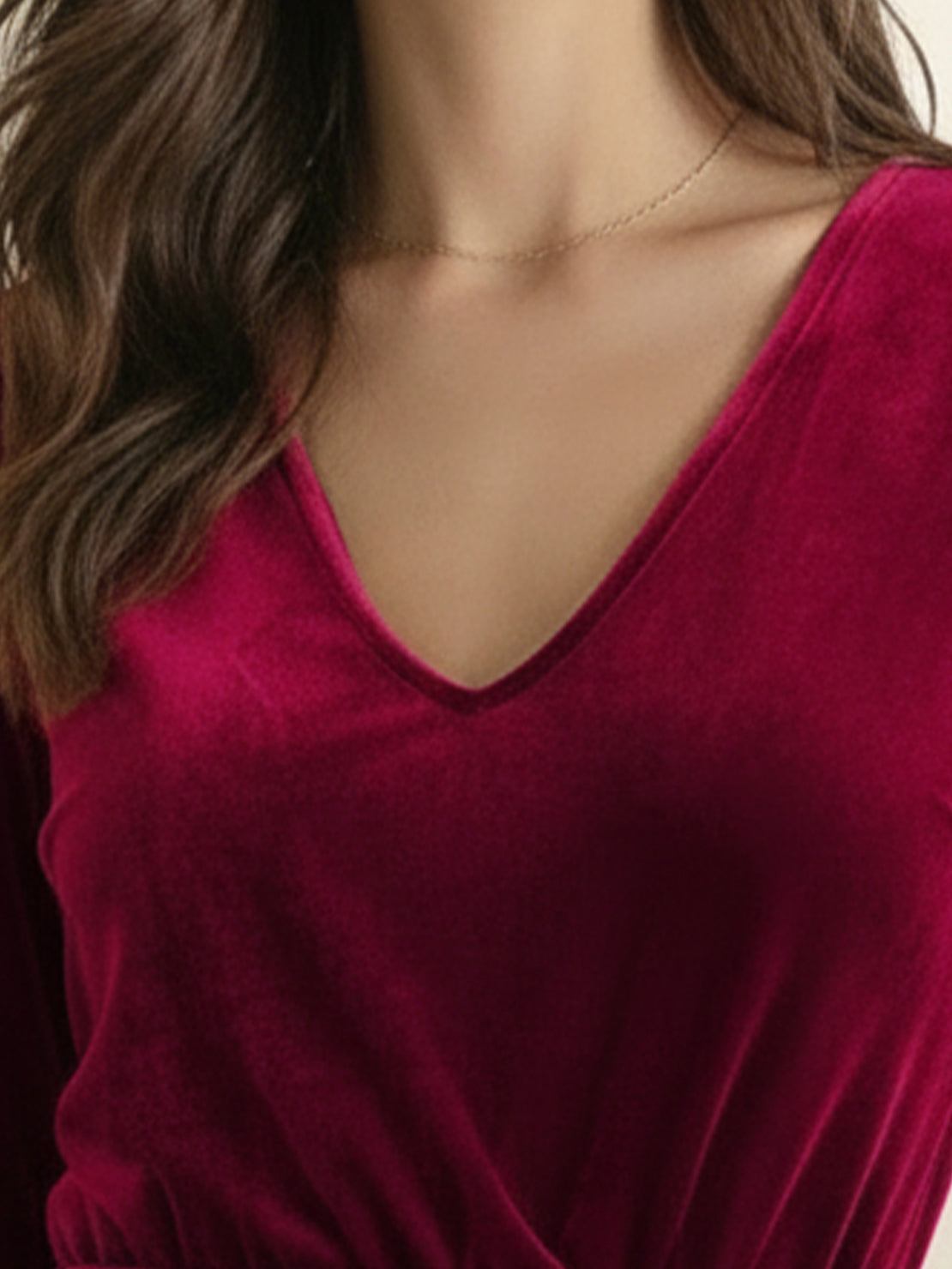 Woman wearing deep V-neck velvet suit with long sleeves and wide-leg pants standing indoors