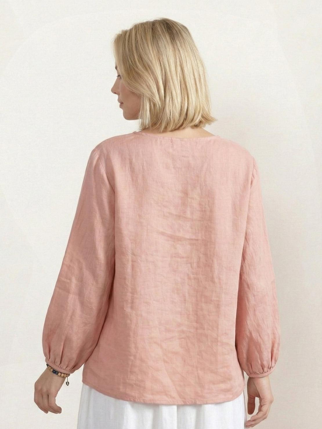 Woman wearing a 100% cotton-linen embroidered blouse with balloon sleeves and gathered cuffs