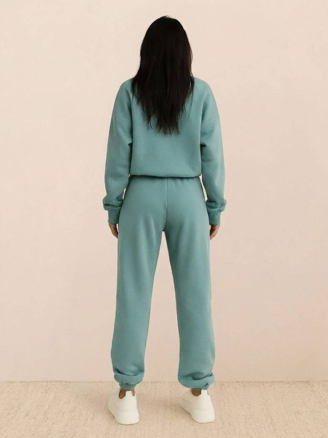 Woman wearing a cotton-blended two-piece tracksuit with high collar and deep zipper, showcasing athleisure style and comfort