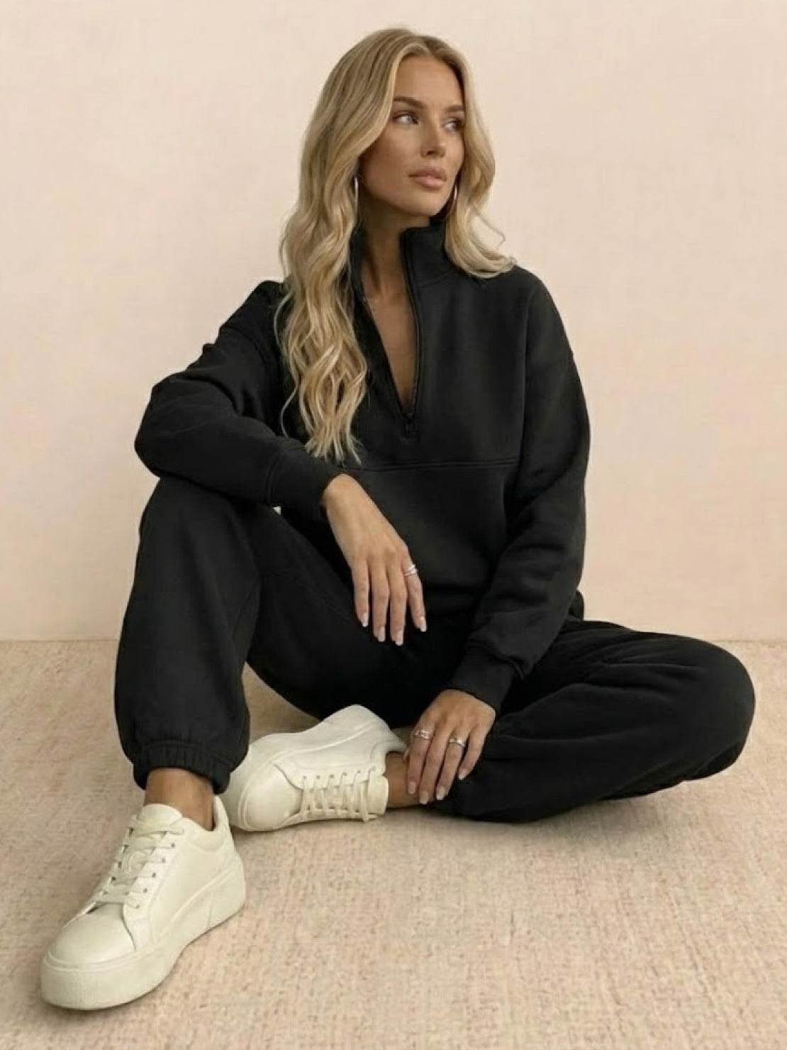 Woman wearing cotton-blended two-piece tracksuit with high collar and deep zipper outdoors