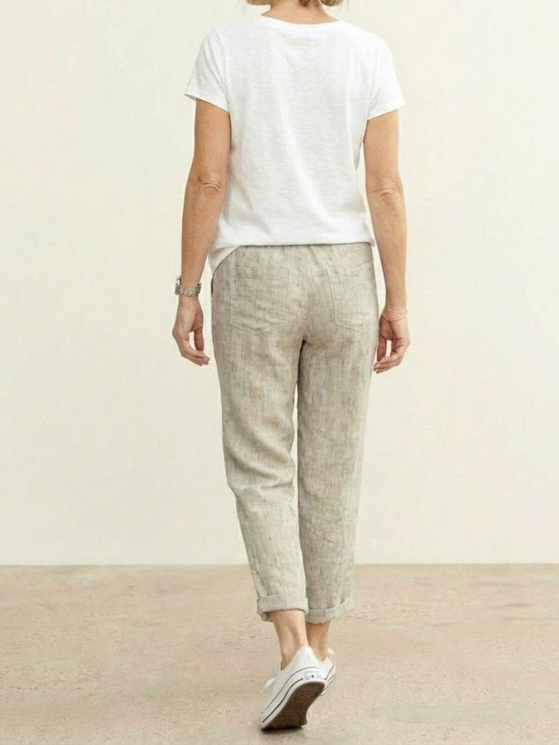 Woman wearing breezy relaxed fit straight pants walking outdoors on city street