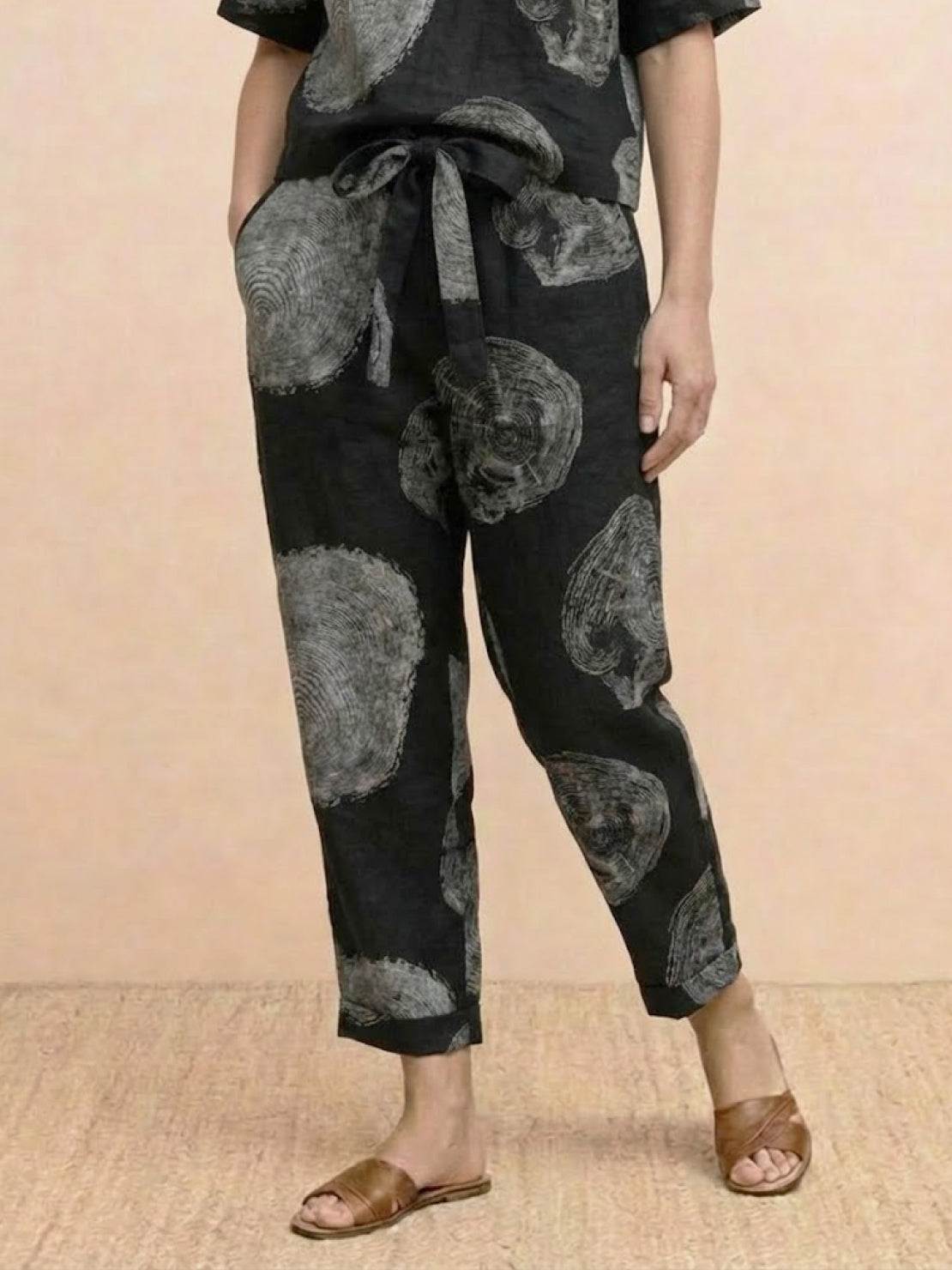 Model wearing relaxed 100% cotton linen set with short-sleeve top and straight-leg pants in monochrome tones