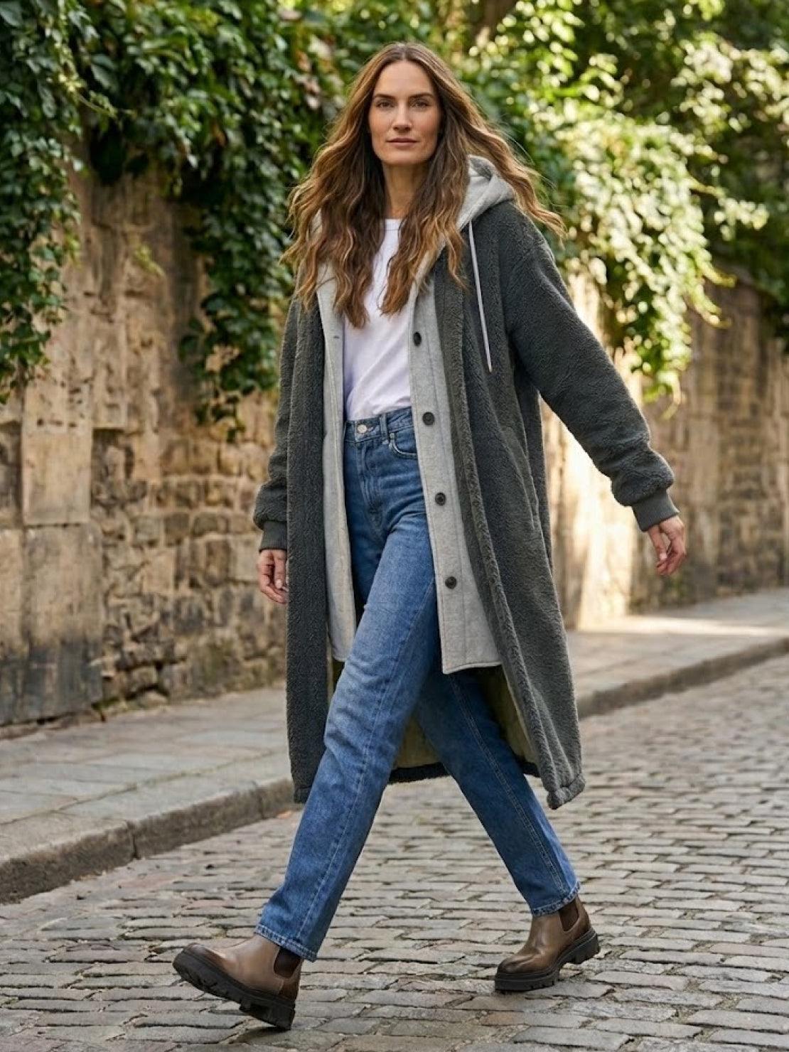 Woman walking outdoors wearing an everyday wear oversized sherpa long coat with cozy lining and casual jeans