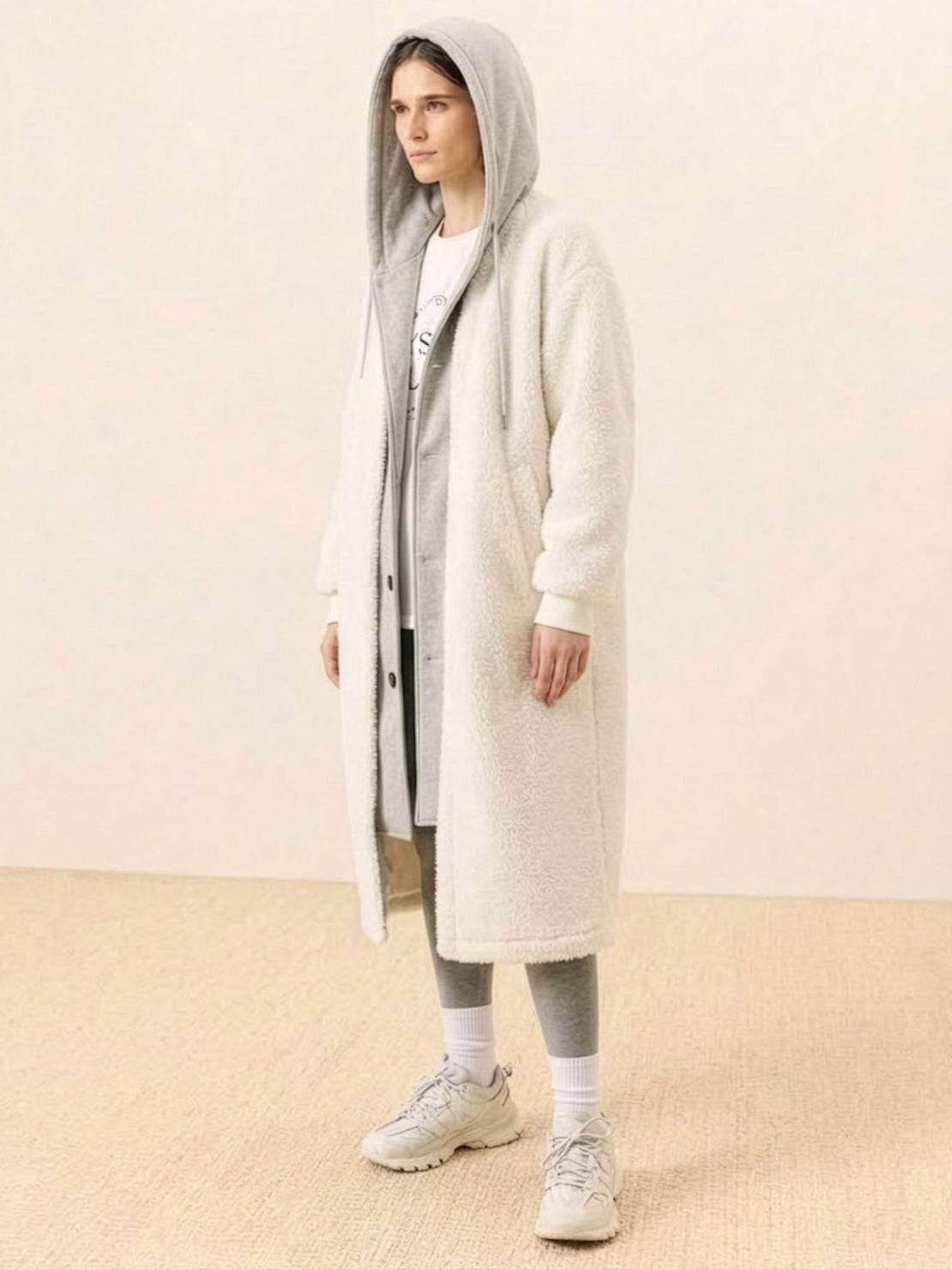 Woman wearing a cozy, oversized sherpa long coat with hood, perfect for everyday wear oversized coat, styled with casual athleisure outfit