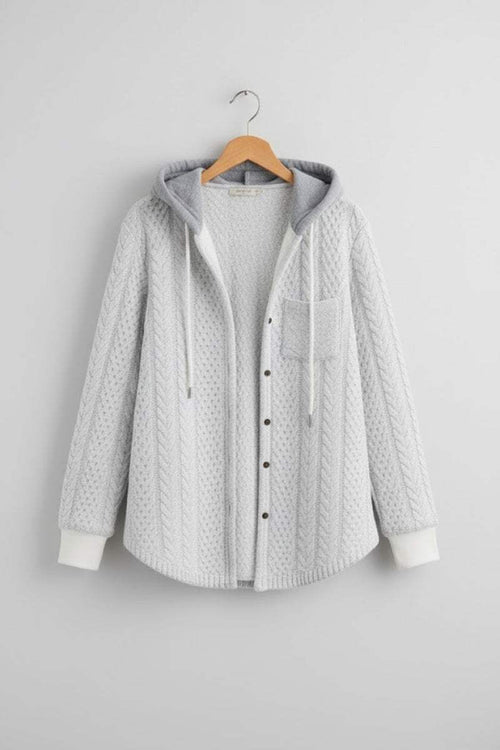 Light grey Highland Plaid Shacket with hood, button-front closure, and front pocket hanging on wooden hanger against grey wall