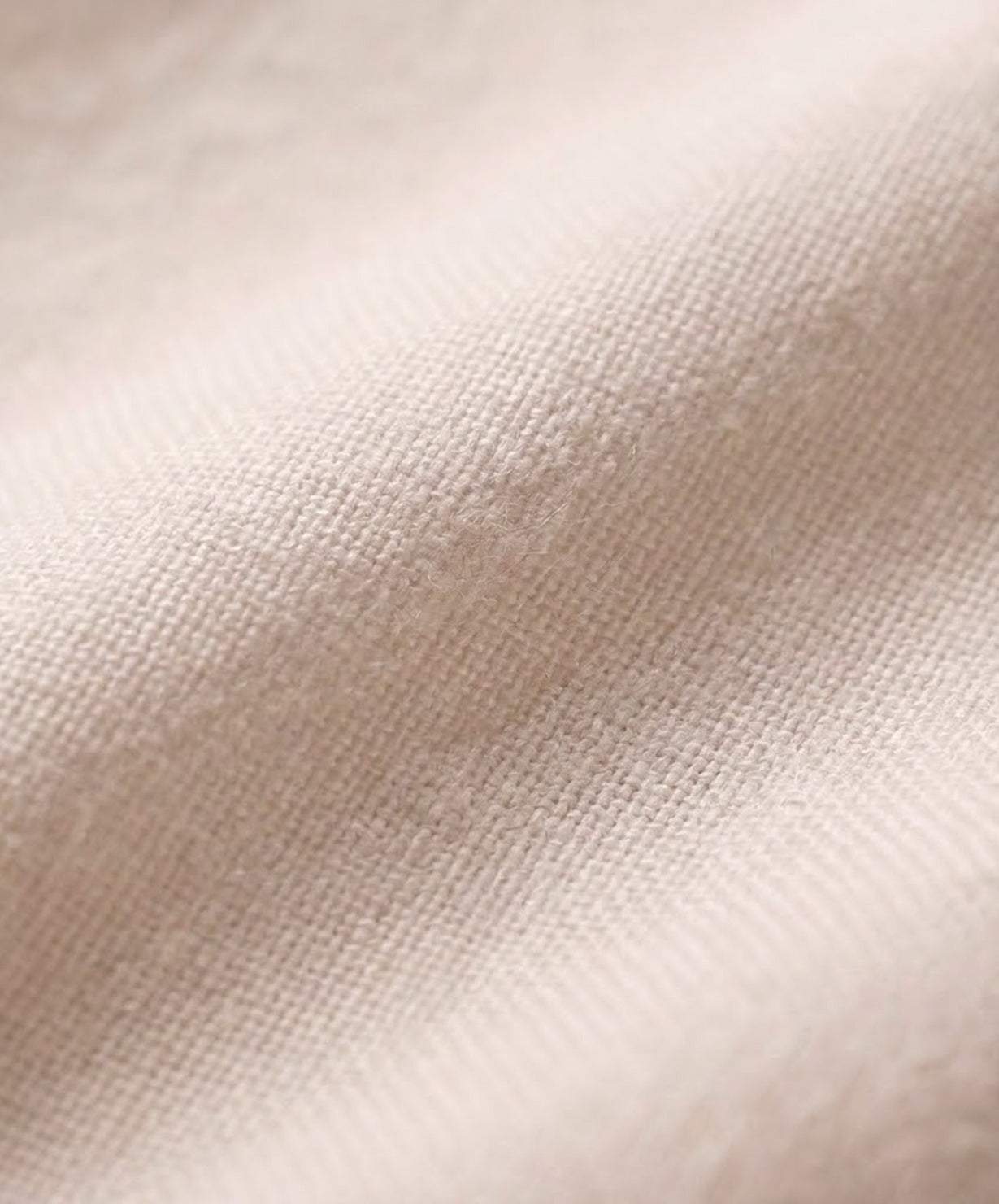 Close-up of soft lightweight beige cotton fabric for short-sleeved pullover and wide trouser matching set