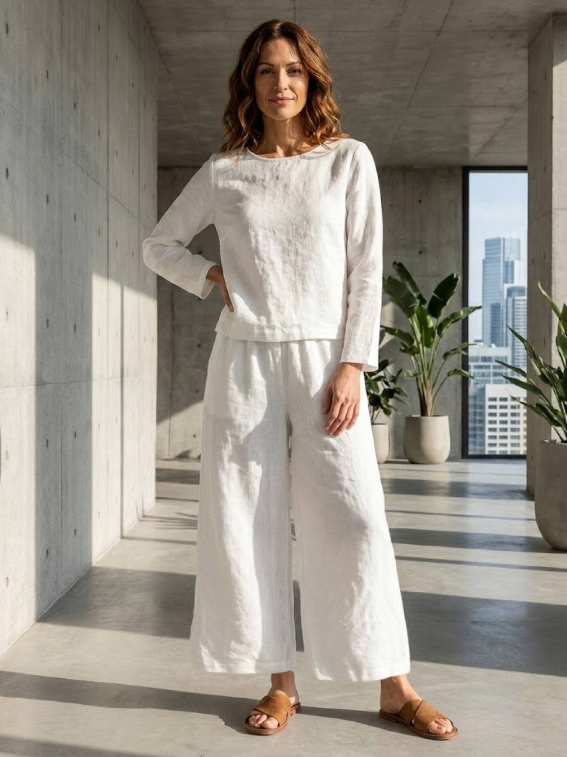 Woman wearing loose solid color two-piece set with a round-neck top and wide-leg pants on a plain background