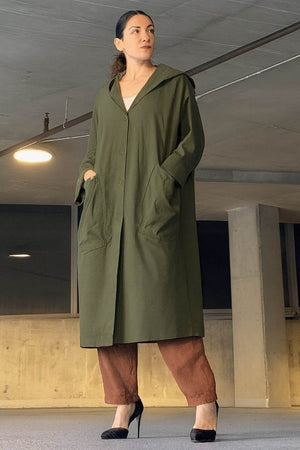 Oversized water-resistant green windbreaker jacket with hood and large pockets, waterproof design.