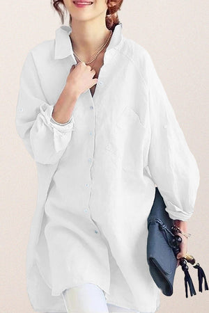White oversized linen shirt with relaxed fit and button-down front, styled casually with rolled-up sleeves and a collar.