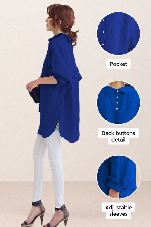 Woman wearing oversized linen shirt in blue with back buttons, pocket detail, and adjustable sleeves, styled with white pants and heels
