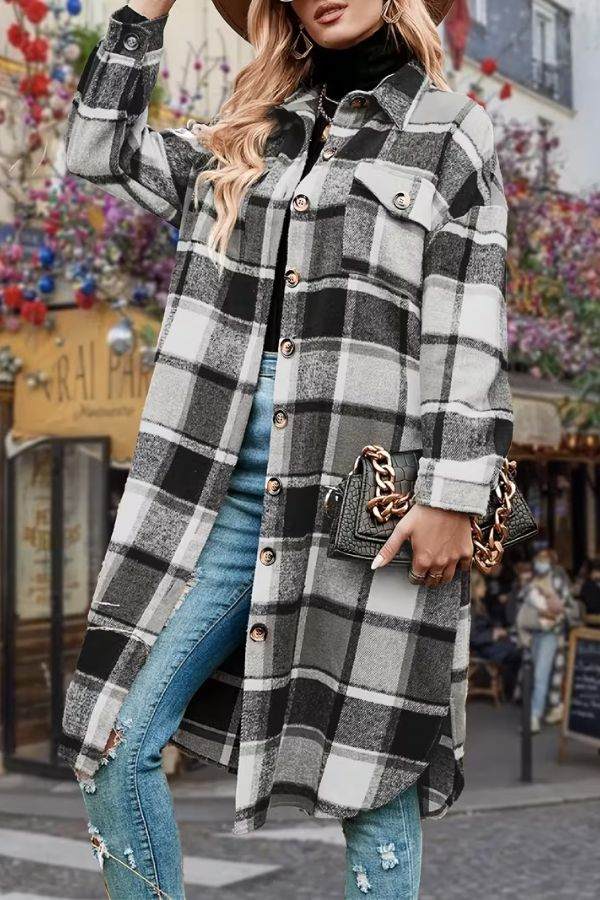 Oversized medium-length plaid overshirt in black and white with button closure and chest pockets, worn with jeans and a black turtleneck.