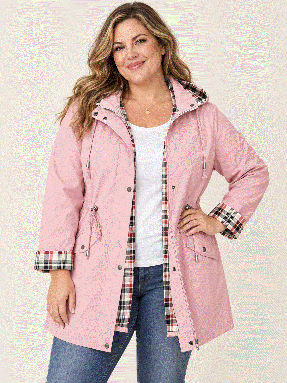 woman wearing plaid-lined hooded rain jacket with waterproof shell and drawstring waist outdoors