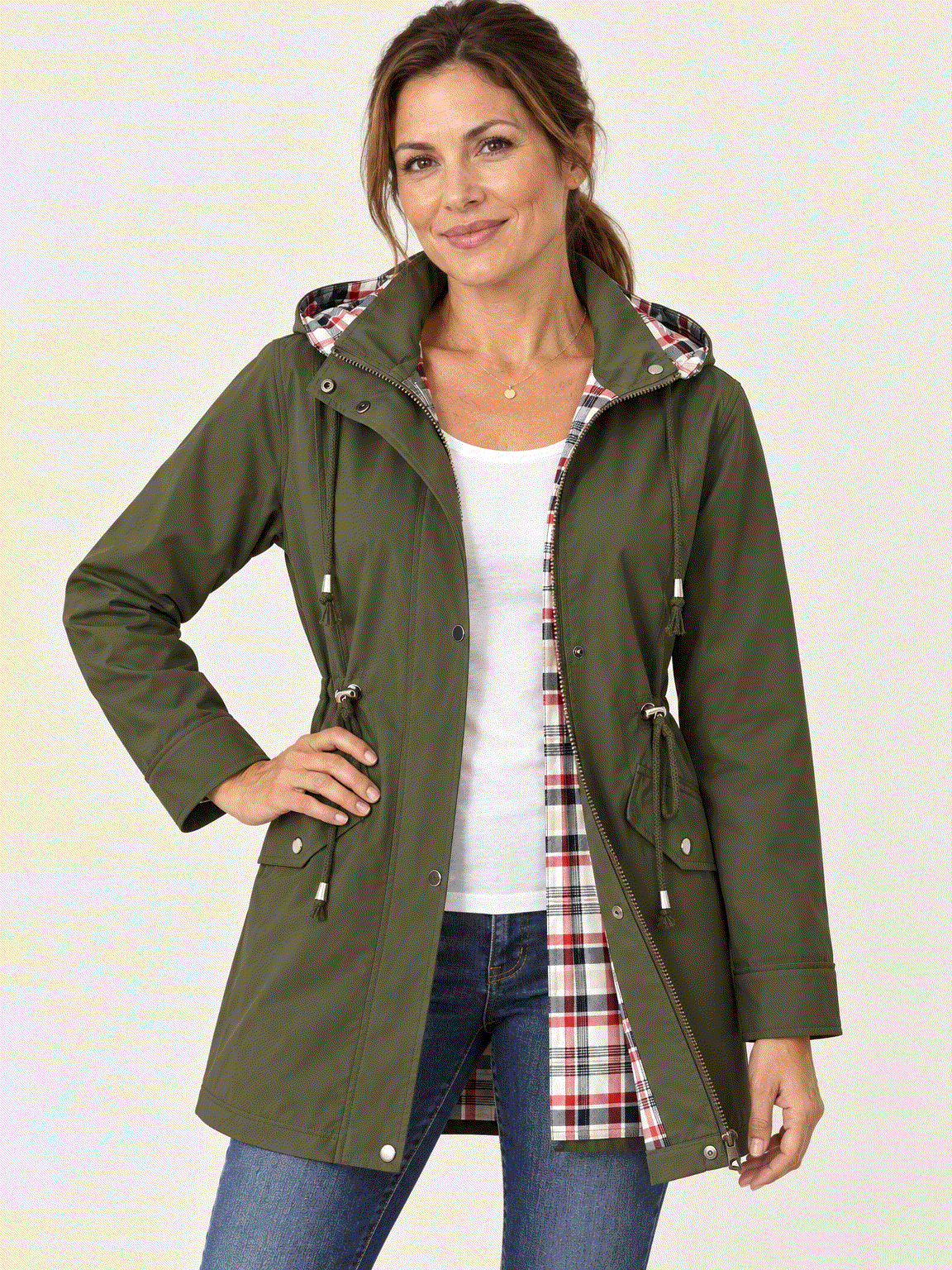 Woman wearing a plaid-lined hooded rain jacket with a waterproof shell and adjustable drawstring waist