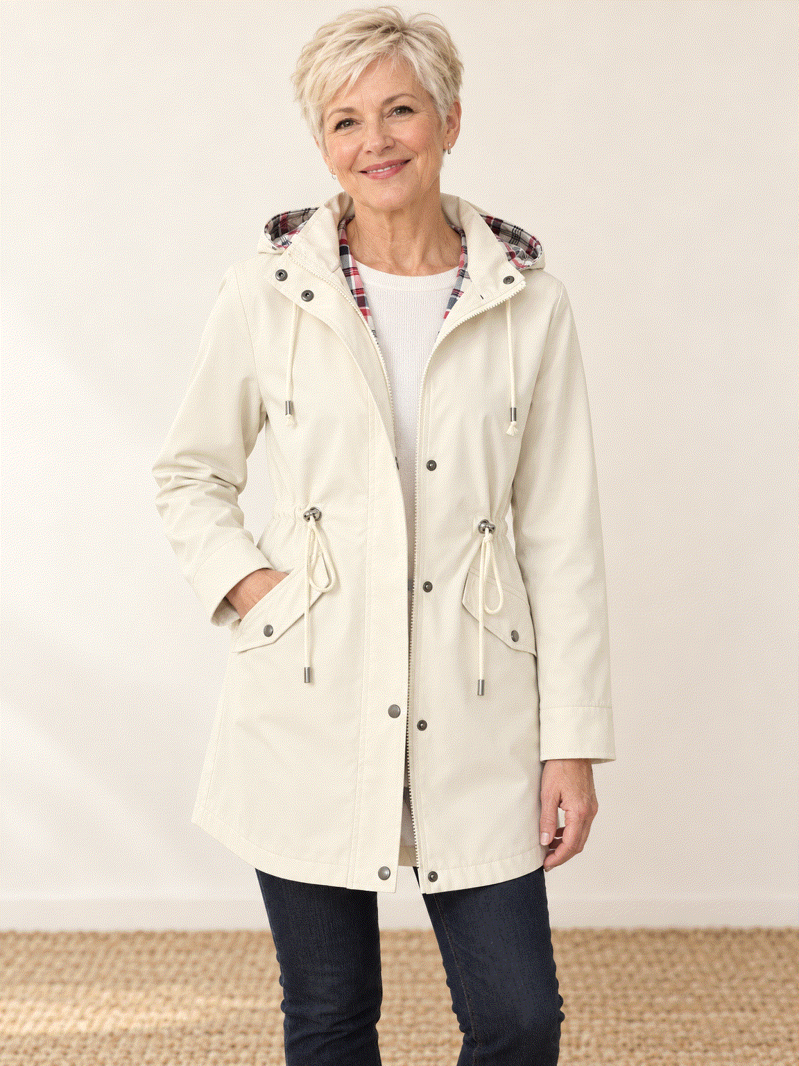 woman wearing plaid-lined hooded rain jacket with red and cream tartan lining outdoors
