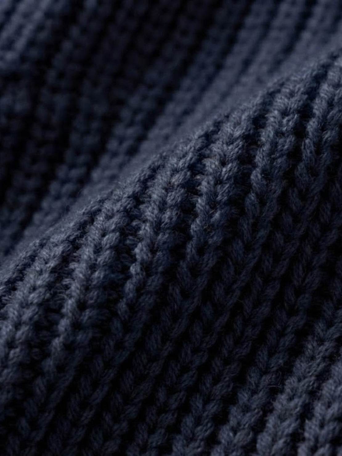 Close-up of navy blue relaxed fit oversized knitwear cardigan fabric texture