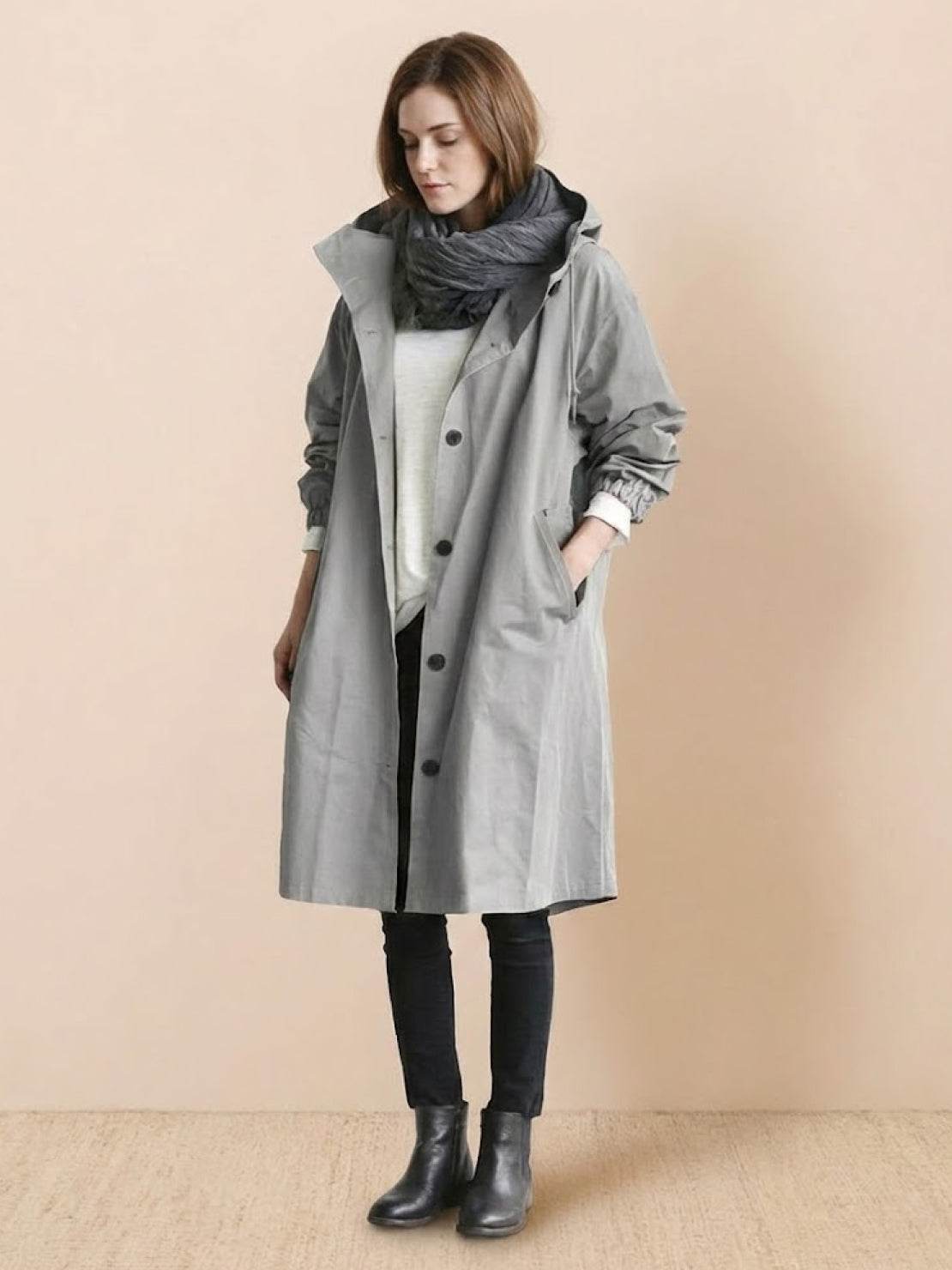 Woman wearing oversized gray Rain Couture Windbreaker with scarf and black boots, water-resistant long jacket style