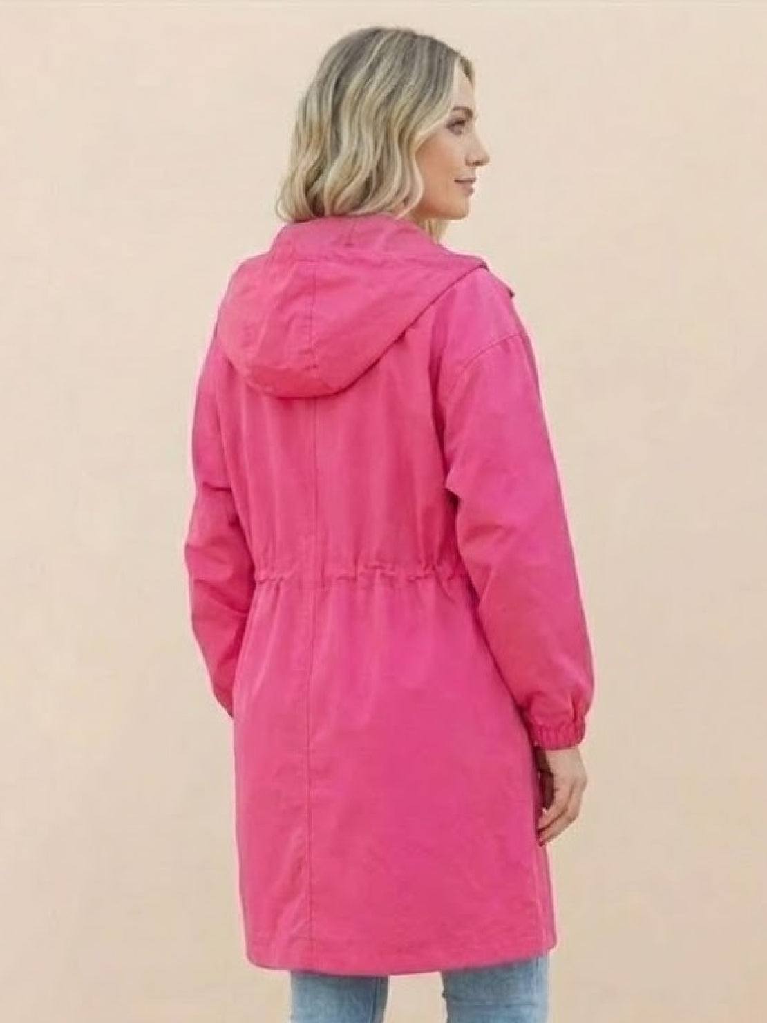 Woman wearing pink Rain Couture Windbreaker windproof water-resistant oversized jacket with hood, back view
