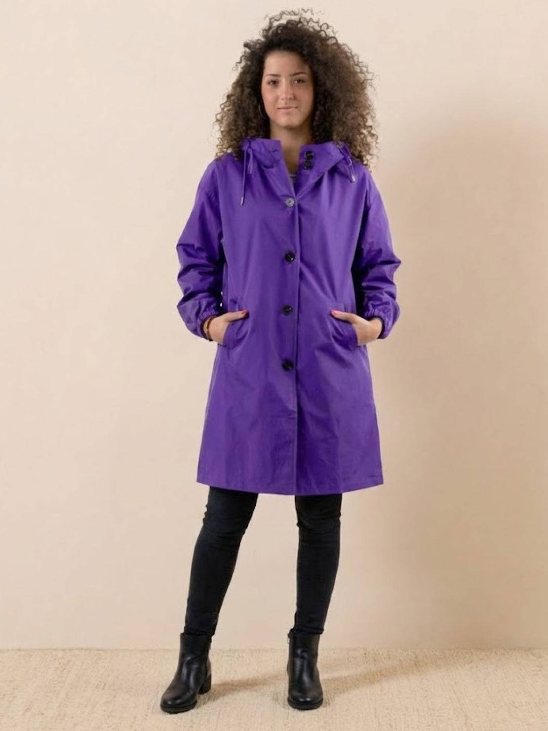 Purple oversized Rain Couture Windbreaker on woman with hood and black buttons, water-resistant jacket for rainy weather