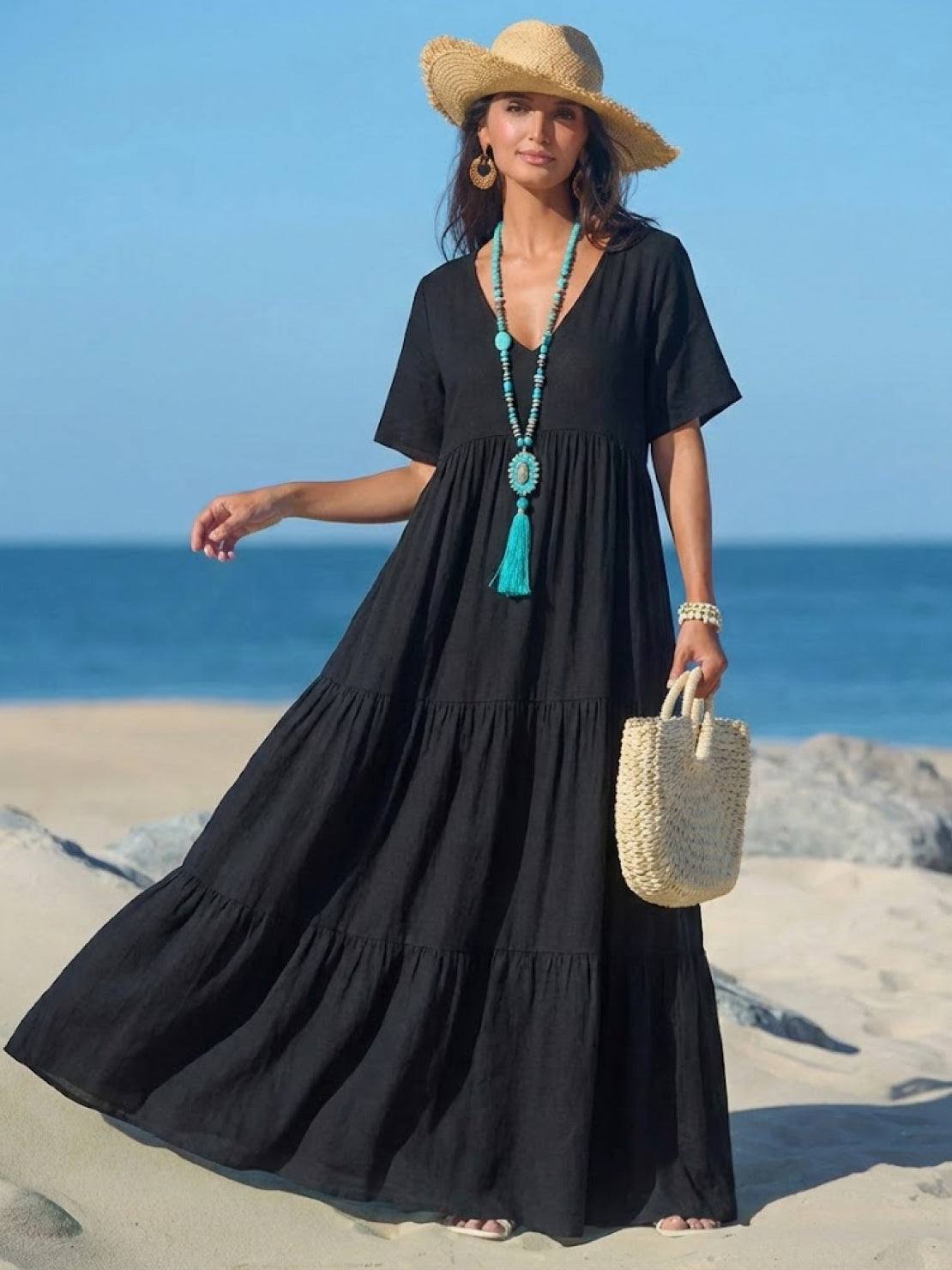 Woman wearing a flowy V-neck two-tiered maxi swing dress in solid color with irregular hemline and draped sleeves
