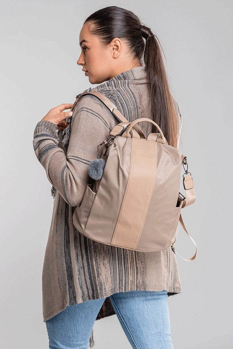 Woman wearing beige anti theft waterproof fashion backpack with adjustable straps and multiple compartments